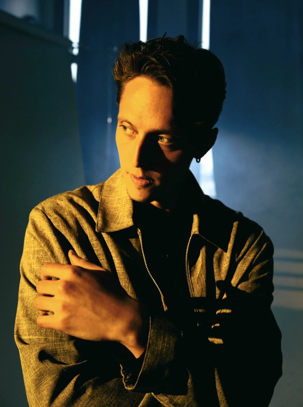 Portrait of Evan Luza in warm light, arms crossed.